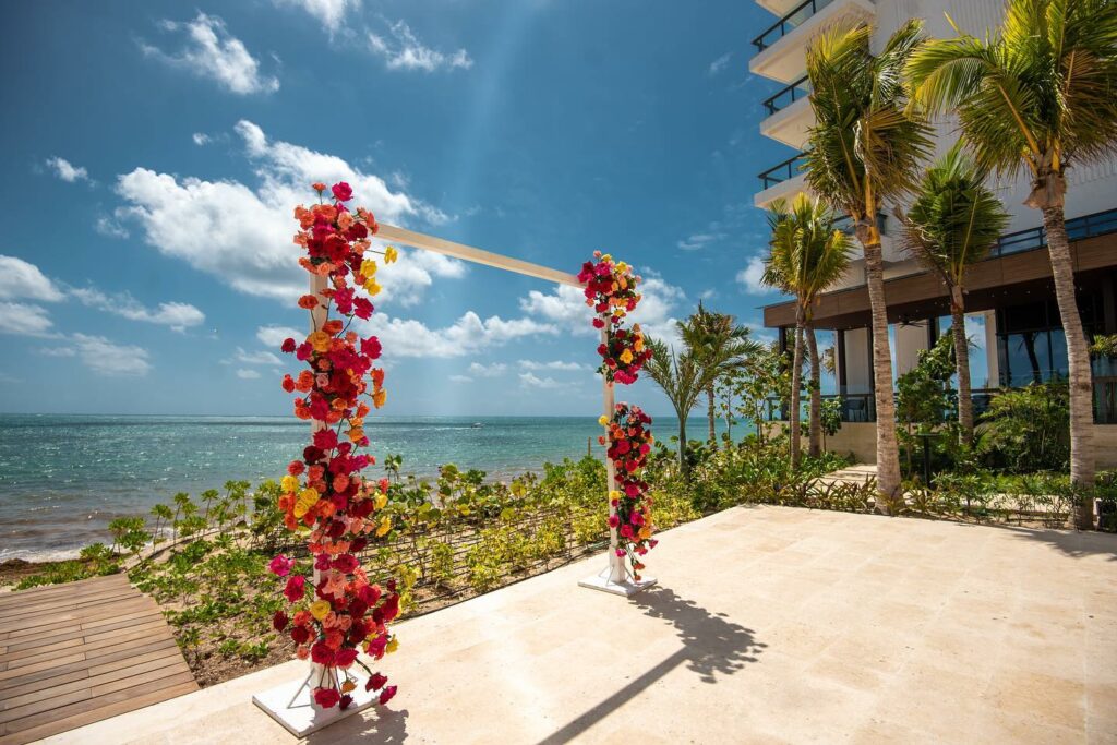 Wedding arch with pink and red flowers at the ocean front terrace