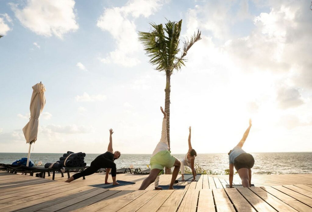 yoga class on a wooden deck with ocean view