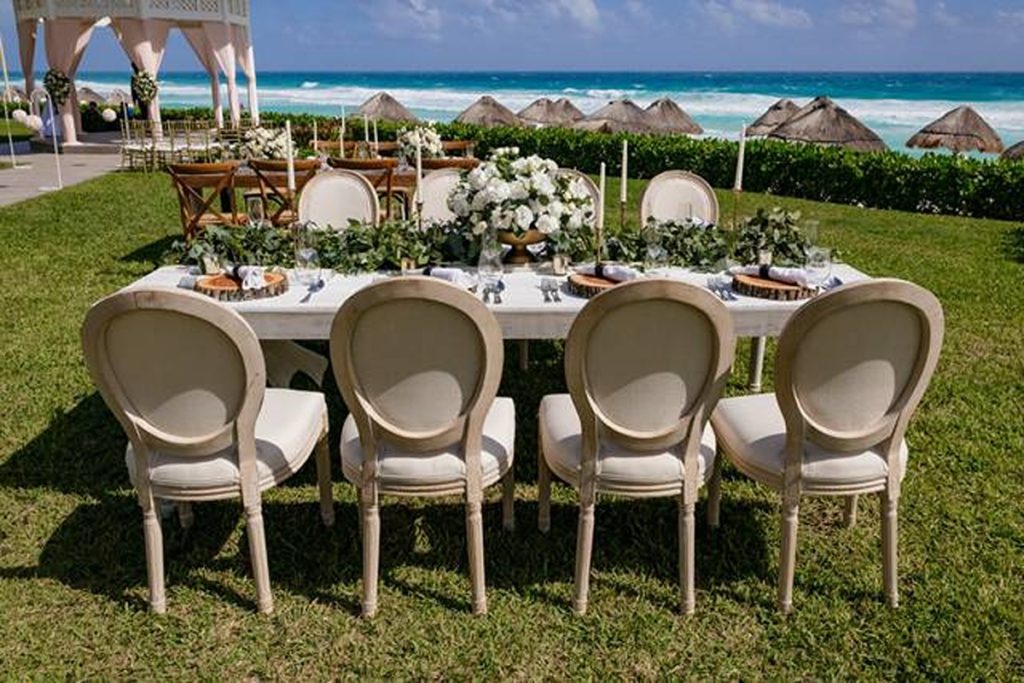 garden wedding table with light wood chairs overlooking the sea