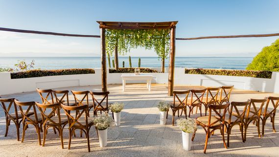 Resort wedding terrace with wooden gazebo and wooden chairs