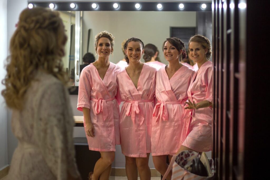 bridesmaids in pink robes posing for a pic