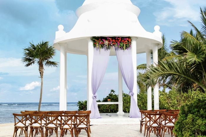 Grand Palladium Riviera Maya Ocean Facing Gazebo with wooden chairs, white drapes and flowers