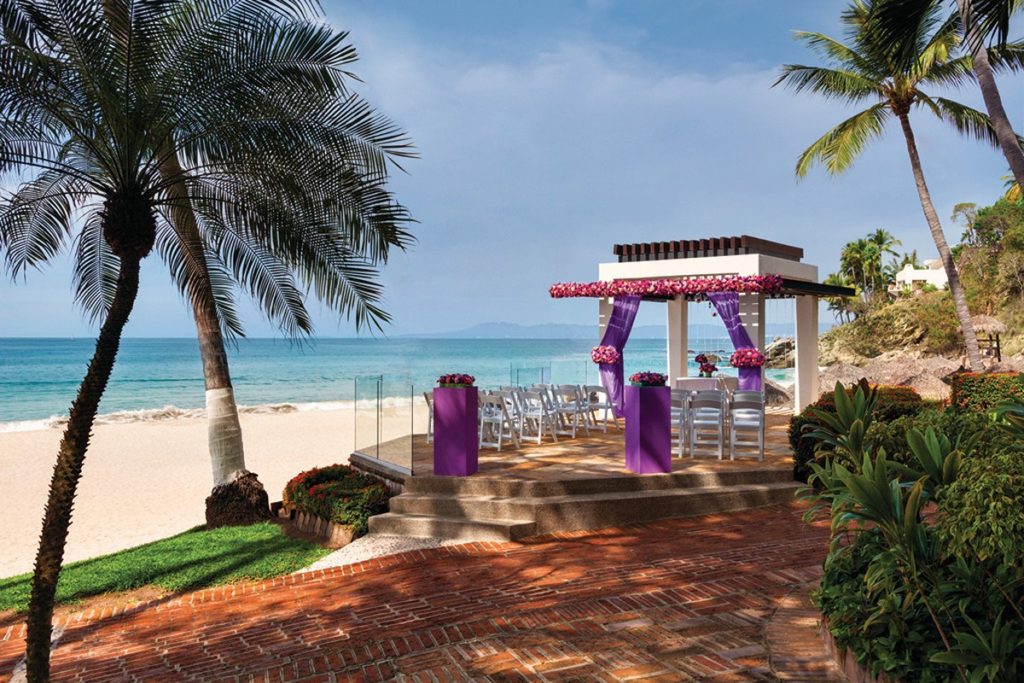 resort wedding gazebo at the beach shore with white chairs