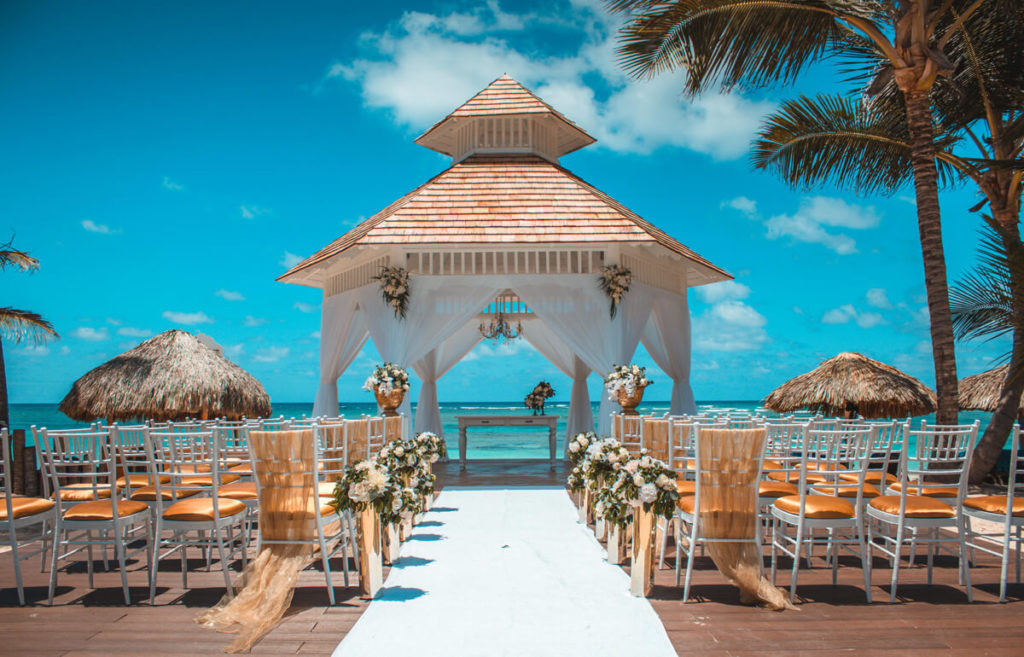 Royalton Bavaro wedding ceremony at the wedding gazebo with orange and white tiffany chairs overlooking the sea
