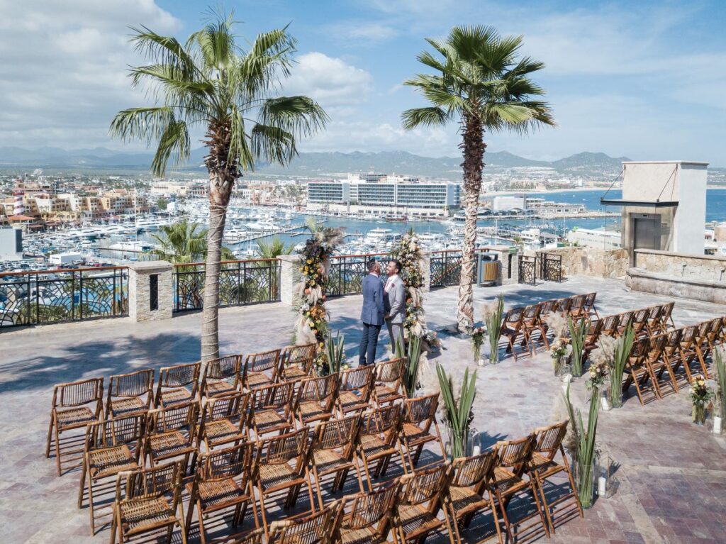 A same sex couple getting married on a rooftop with marina view in los cabos