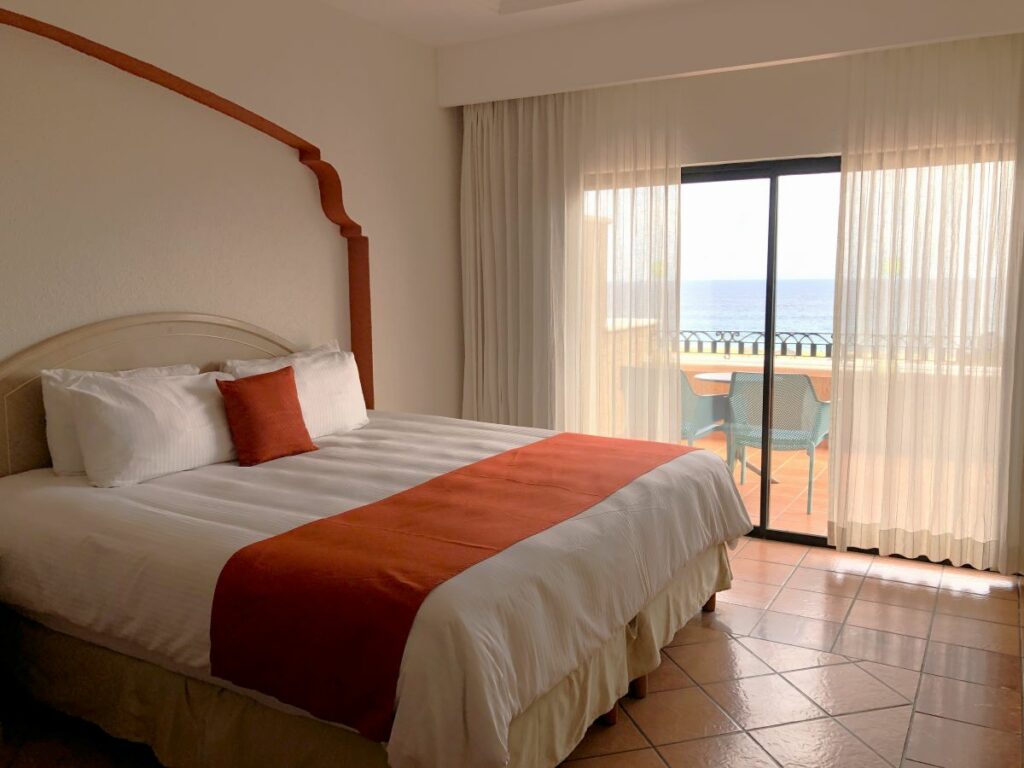Hotel room with a king size bed and a terrace with ocean view