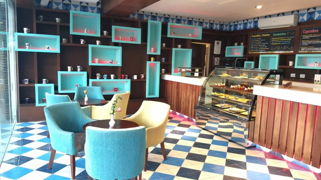 caffee with colorful furniture and cupcakes and paninis in a fridge