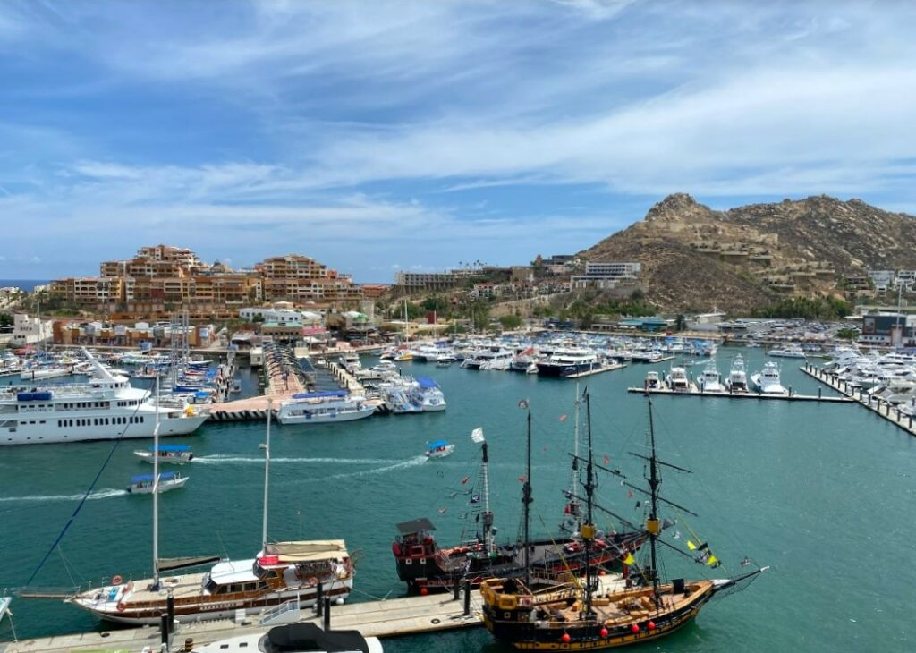 A view of cabo san lucas marina with boats and yatchts and the mountains at the back