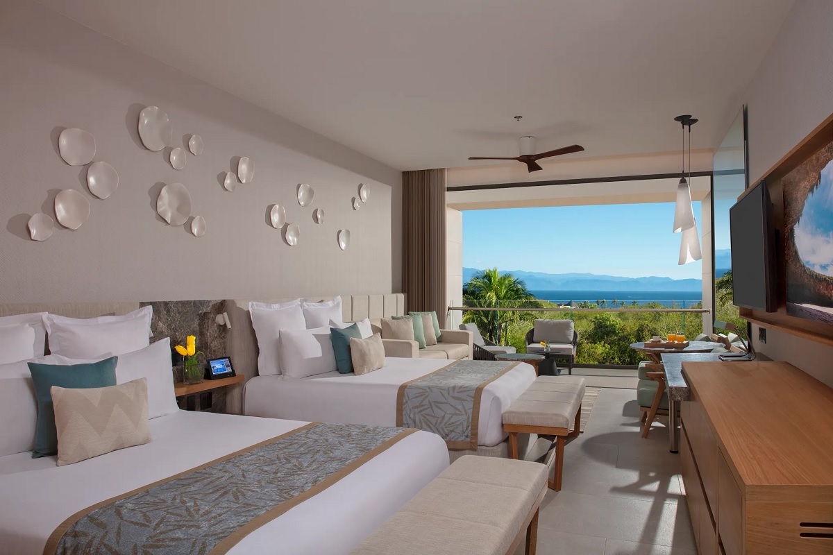 Dreams Bahia Mita Surf And Spa Room With Two Beds With White Linens And Blue Accents Sitting Area Tv And View Of The Foliage And Ocean 