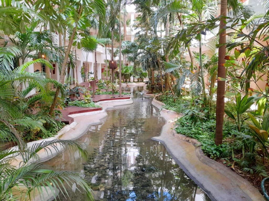indoor gardens of a beach hotel in cancun with a small pond