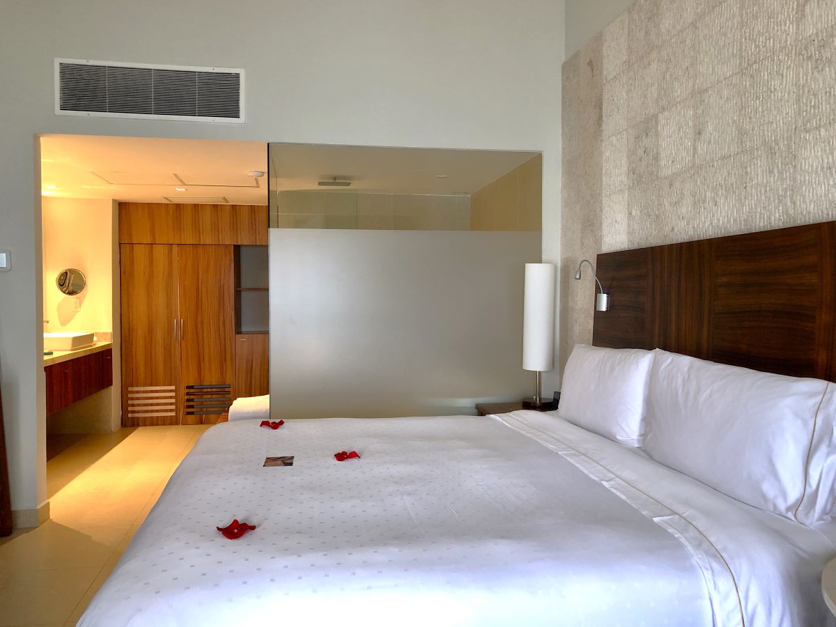 hotel room with neutral tones and wooden furniture and one king size bed and