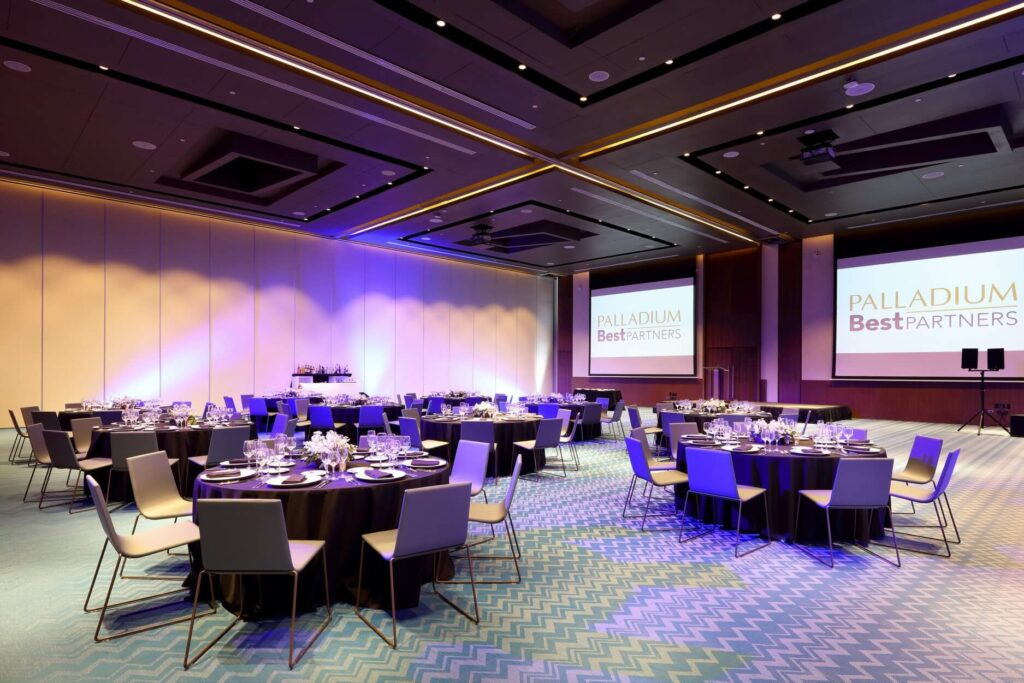 ballroom with round tables and big projection screens