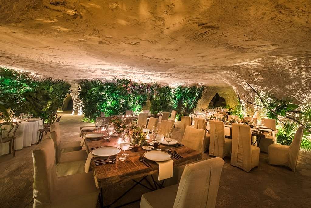 Destination wedding reception inside the cave with lots of greenery and flowers at hotel xcaret