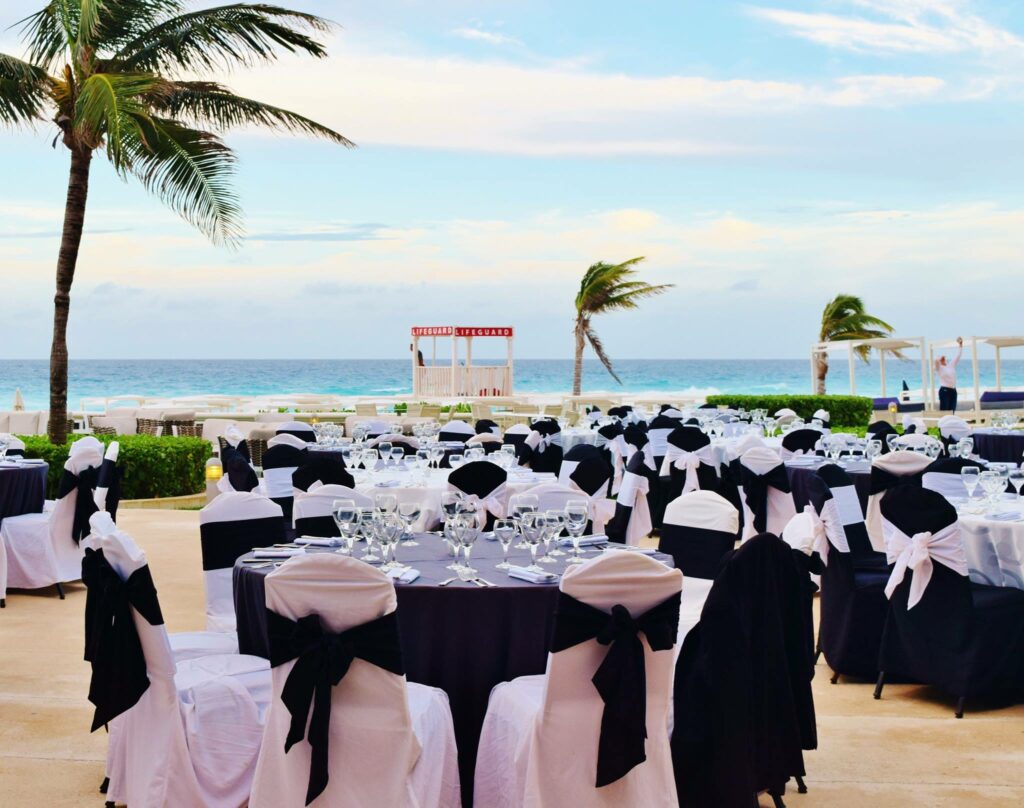 ocean view terrace with a reception set up with white and black tablecloths
