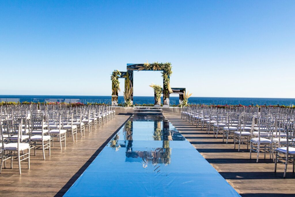 impressive wedding ceremony gazebo set up at a rooftop terrace, with a mirror aisle and white chairs location grand velas los cabos