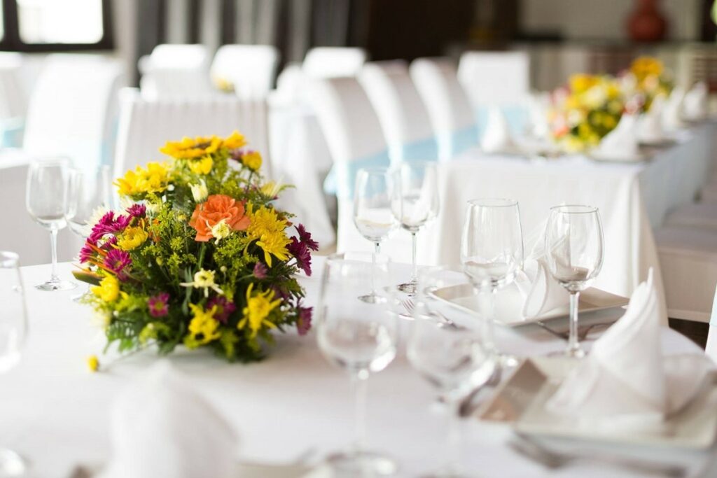 wedding table ste up with white table cloths and colorful flower centerpieces