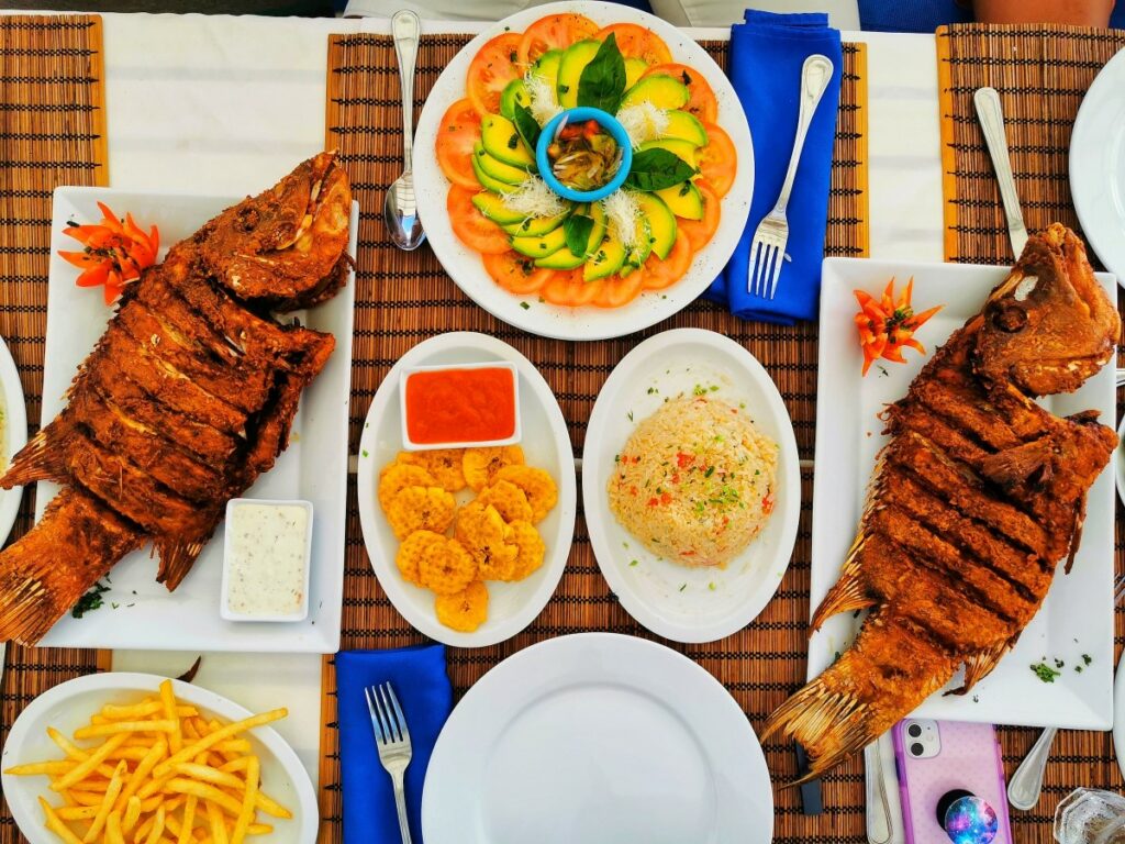 A table set up with traditional Dominican dishes including fried fish, rice and shrimps
