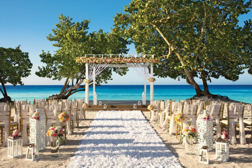 oceanfront wedding gazebo with pink roses and big trees in the background
