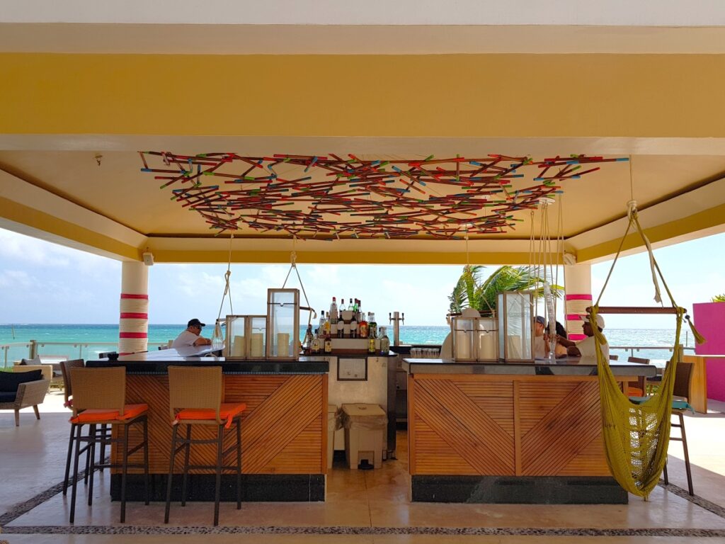 oceanfront bar with hammocks at a beach resort in the riviera maya
