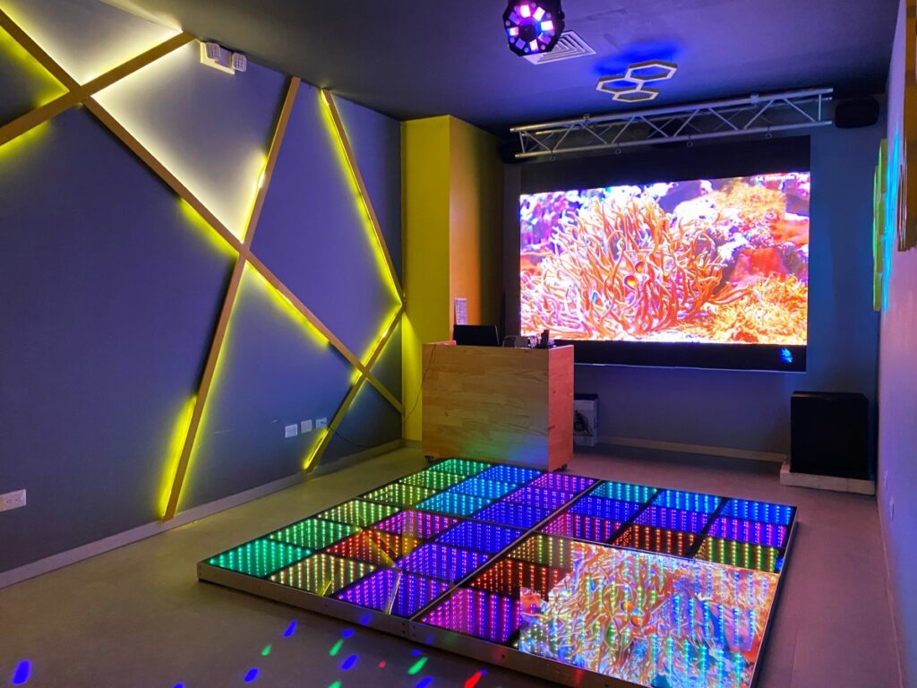 teens nightclub with a light dance floor and a big screen