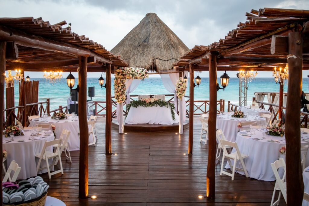 wedding set up on a deck with a palapa roof and ocean view