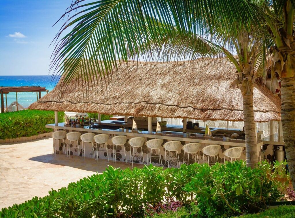 outdoor palapa ceviche bar with high chairs and ocean view