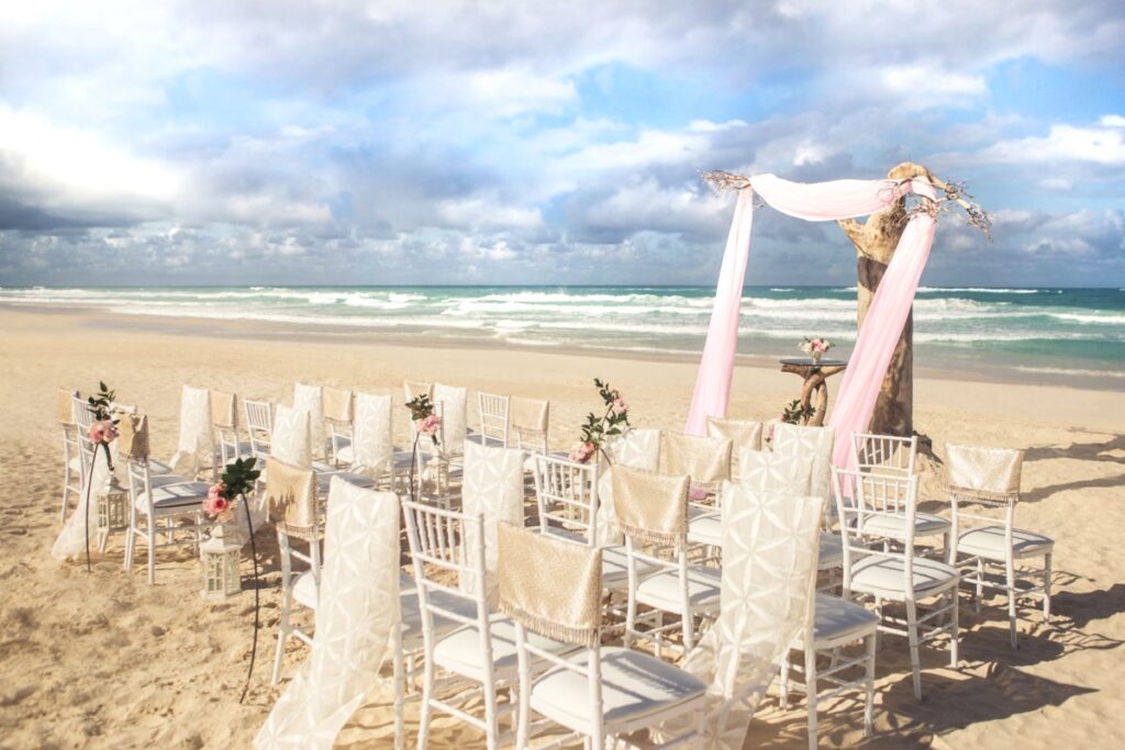 A beautiful wedding ceremony set up in white and pink colors on a beach in Punta Cana