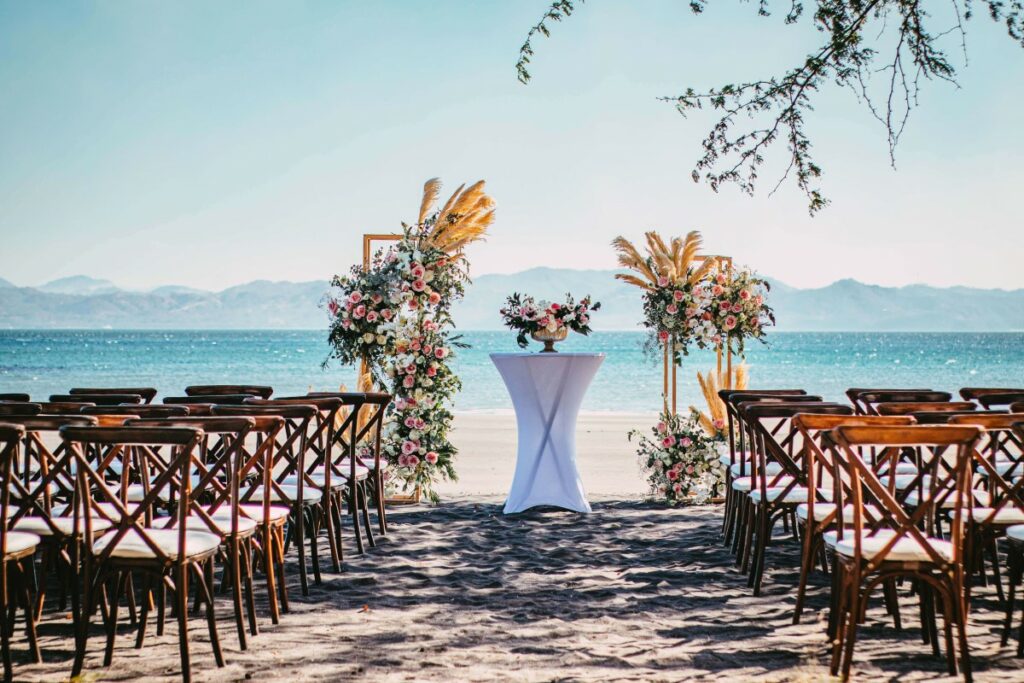 Beach wedding ceremony set up with two pillars with flower arrangements at a resort in costa rica