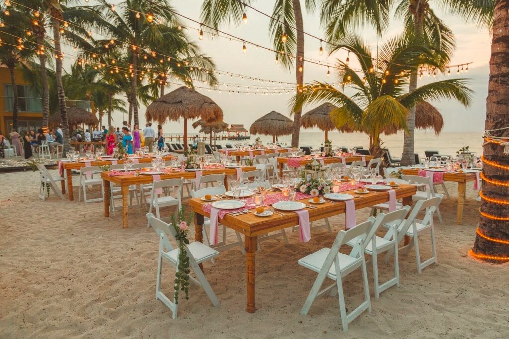 beach wedding set up with rectangular tables and bistro lights