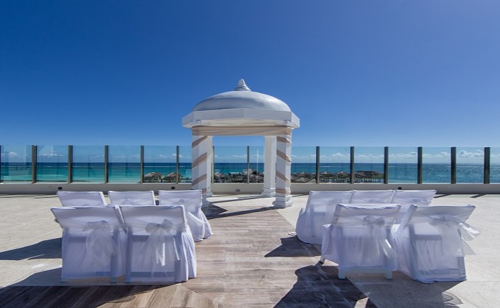 El Dorado Maroma wedding ceremony set-up with white gazebo and white chairs on the ocean front sky deck.