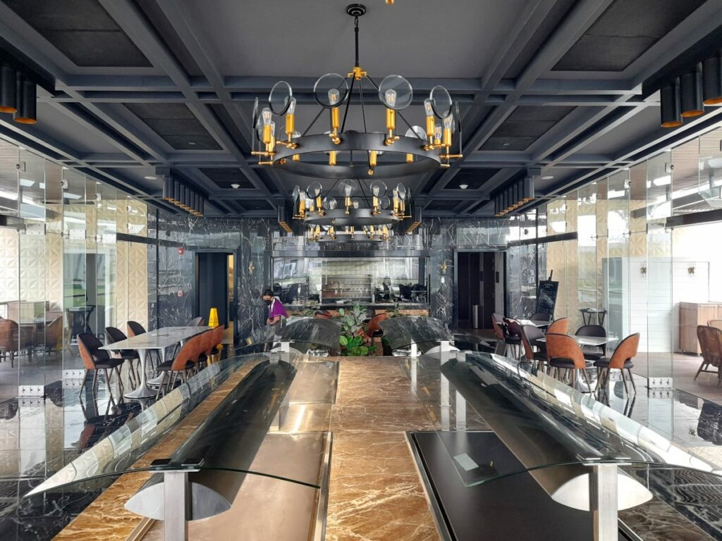Elegant restaurant with glass walls, wood furniture and hanging lanterns