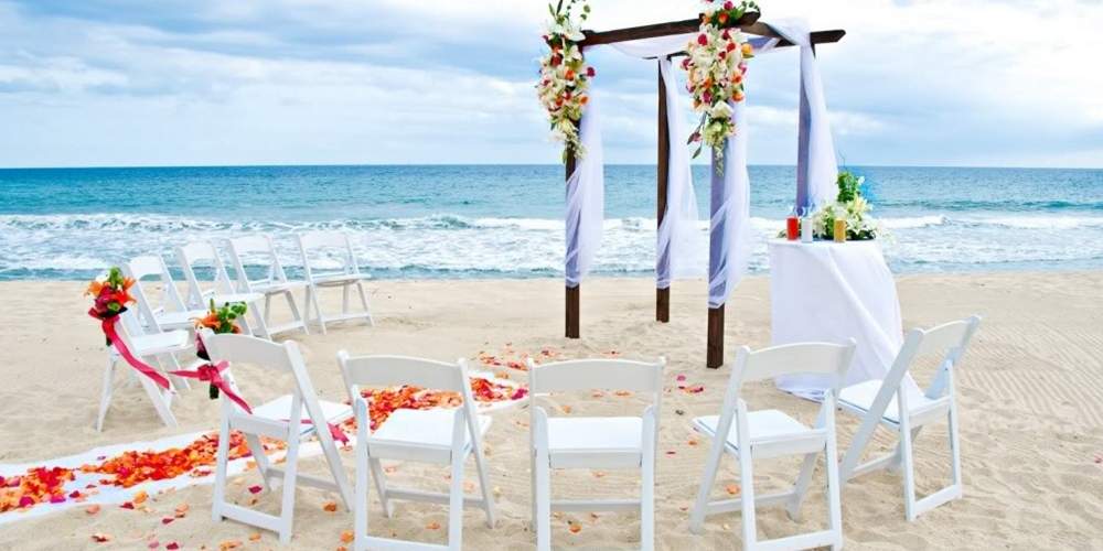 beach wedding ceremony set up with rose petals