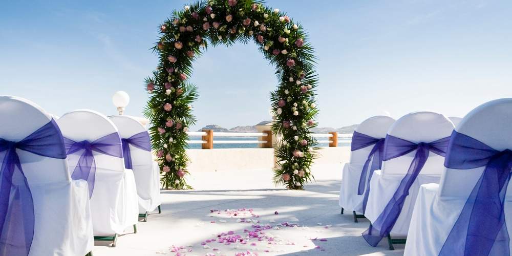 wedding ceremony set up with a flower and leaves arch