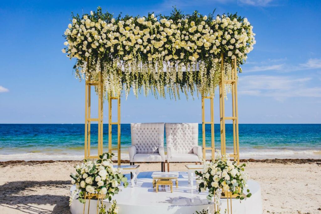 beach wedding ceremony set up with a beautiful arch with flowers