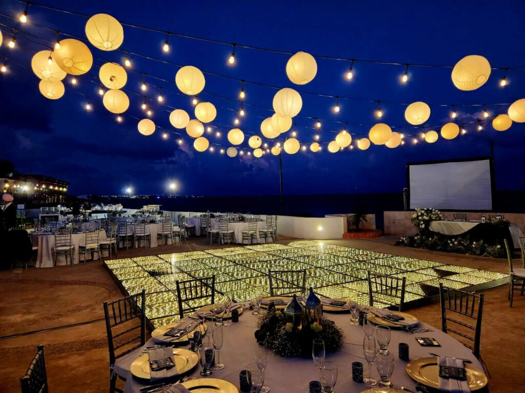 wedding reception at an open terrace with led light dancefloor and hanging lanterns