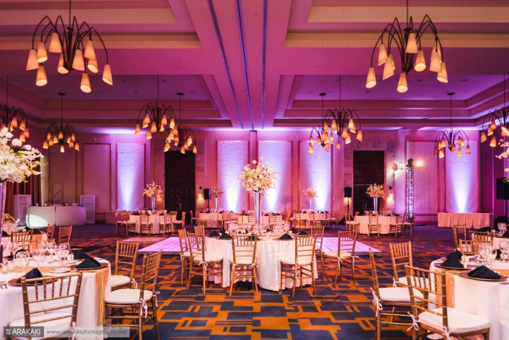 wedding ballroom with chandeliers and pink lights