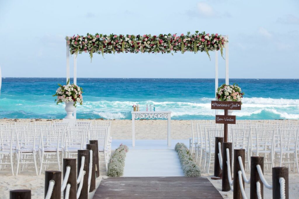 beach wedding ceremony with a gazebo with flowers