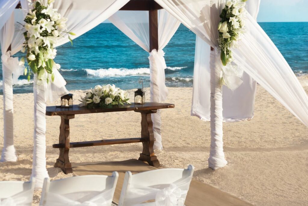 wedding gazebo with white drapes and white flower arrangements
