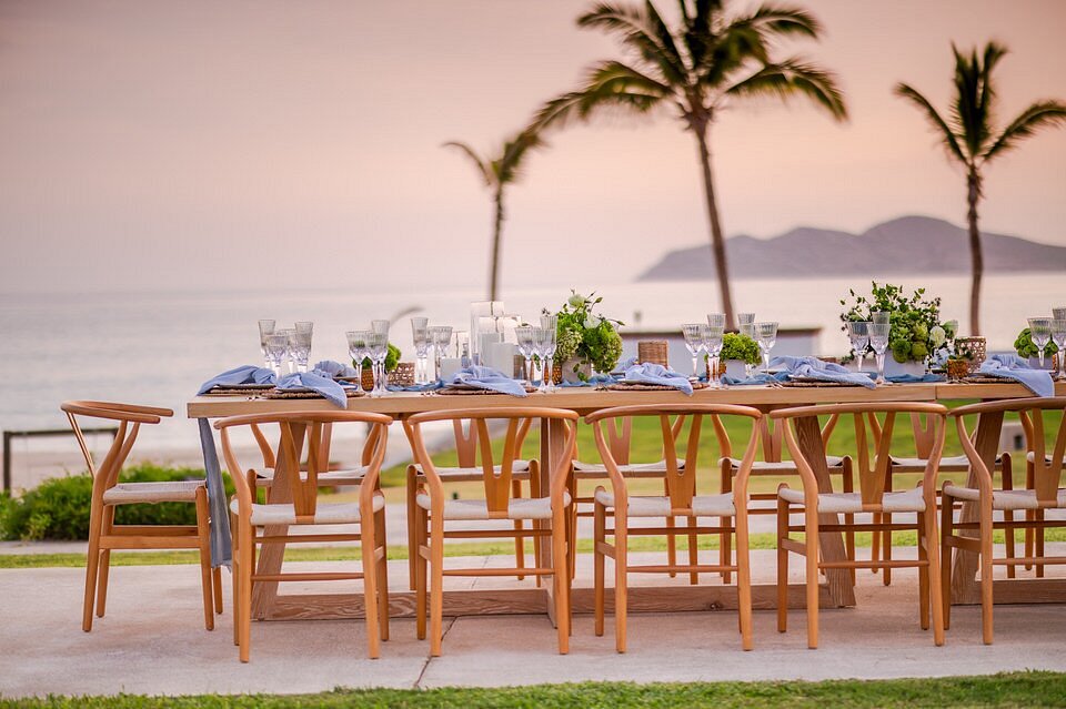 wedding reception table with wooden furniture and ocean views