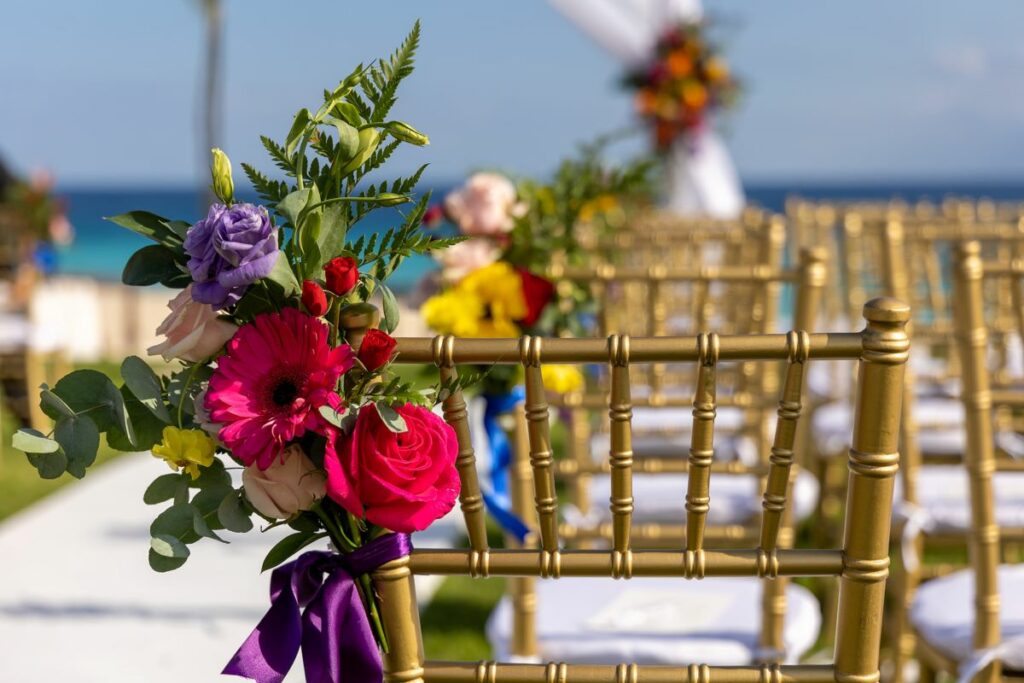 wedding ceremony setup with golden chairs and colorful flowers