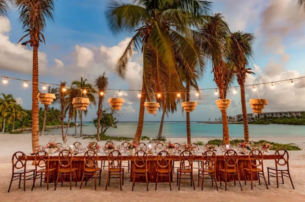 reception dinner set up with hanging lanterns in a beach in tulum