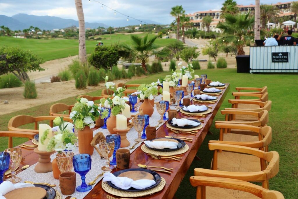 a wedding reception table at an outdoor lawn area of a beach resort in mexico