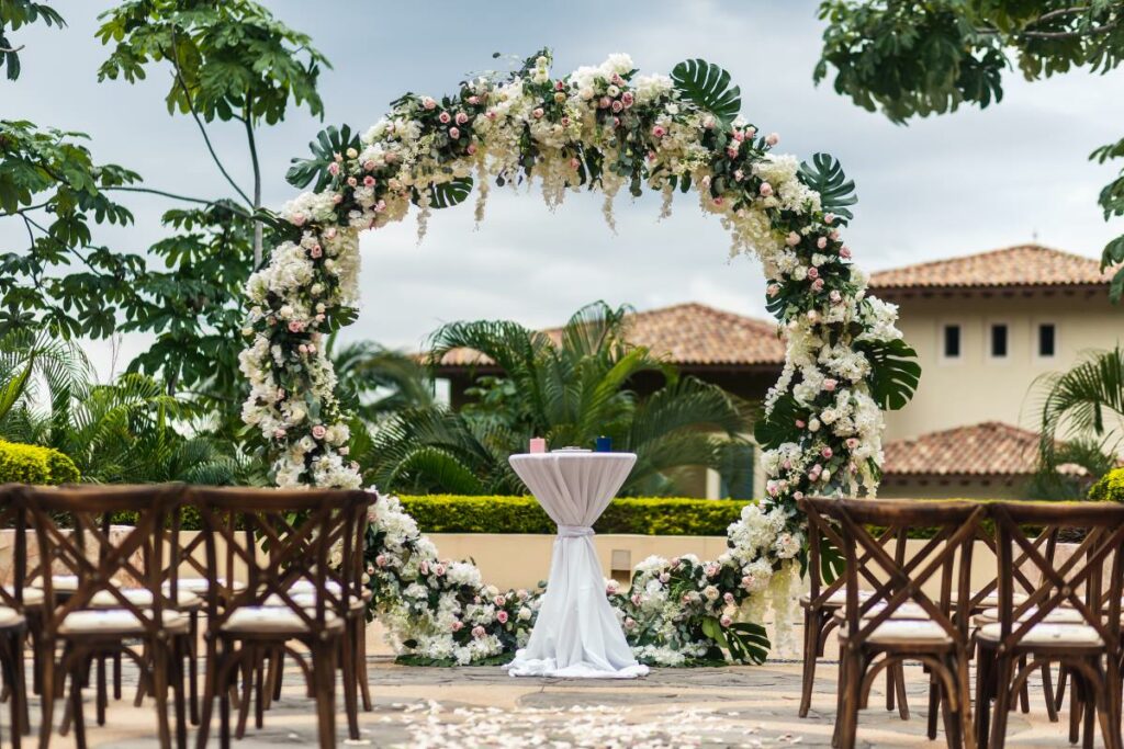 a beautiful flower arch for a wedding at an all inclusive resort in puerto vallarta