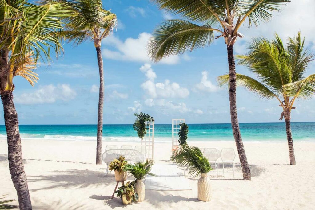 beach wedding ceremony in cancun among palm trees