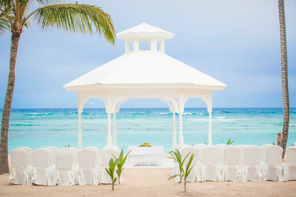 Beach gazebo with palm trees and white chairs set up for a wedding ceremony at Punta Cana
